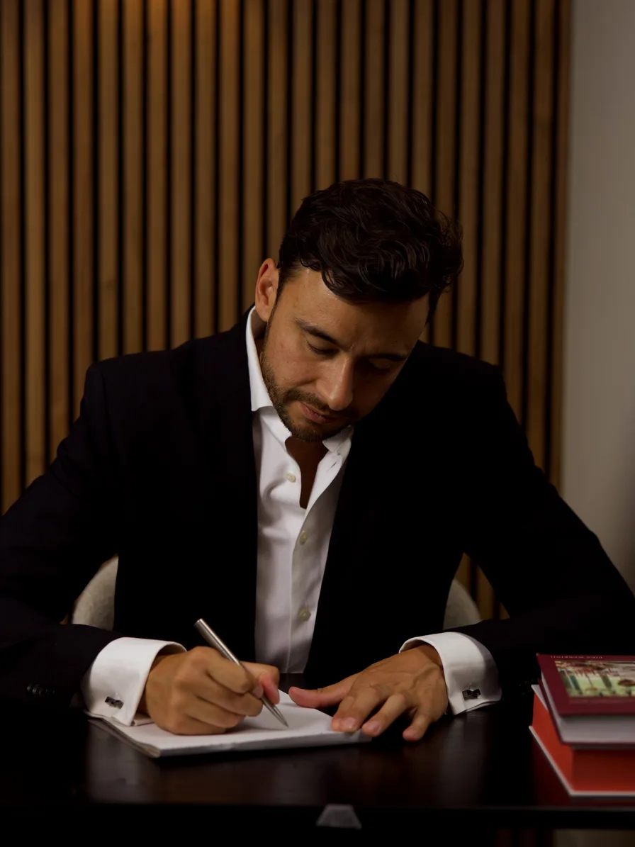 Dennis Makarawung maakt aantekeningen aan zijn bureau